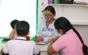 Una maestra junto a jóvenes en un centro de apoyo terapéutico.