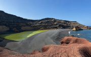 El Charco de los Clicos sorprende por sus aguas verdes rodeadas de arena negra, rocas rojizas y el azul del océano.