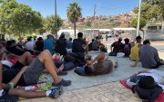 Varios migrantes congregados en los alrededores del Embolsamiento Loma Colmenar, uno de los puntos de acogida, este sábado 22 de agosto en Ceuta.