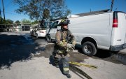 Un bombero pasa junto a un auto quemado, presuntamente incendiado por grupos del crimen organizado, en respuesta a una operación en Jalisco para arrestar a Nemesio Oseguera, líder del violento Cártel Jalisco Nueva Generación, en Tijuana, estado de Baja California.