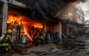 Bomberos enfrentan un incendio en una zona urbana, un escenario que evidencia los riesgos asociados al almacenamiento irregular de materiales inflamables en bodegas clandestinas.