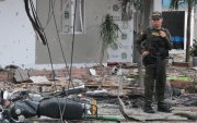 Un policía vigila el área donde ocurrió la detonación de un vehículo cargado con explosivos este martes en Los Patios (Colombia).