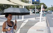 Una mujer se protege con un paraguas del intenso sol el 19 de agosto de 2026 en la plaza América de Valencia.