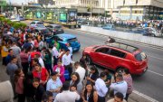 Empleados de oficina permanecen fuera de los edificios tras la evacuación provocada por el fuerte terremoto que sacudió la Ciudad de Guatemala el 8 de julio de 2025.