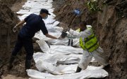 Agentes de la policía nepalí realizan un entierro masivo de víctimas de las inundaciones que golpearon el norte de Nepal.