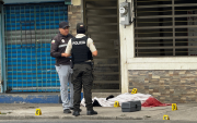 Agentes policiales resguardan la escena del crimen donde fue asesinado un bombero en Machala.