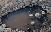 La vía Saracay-Portovelo presenta baches y deterioro mientras soporta el tránsito constante de volquetes con material mineralizado.