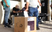 UN CIUDADANO SUFRAGA Y DEPOSITA SU PAPELETA EN UNO DE LAS URNAS O BIOMBOS PARA DEPOSITAR SU VOTO ||