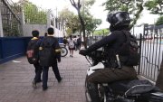 Agente policial custodia el ingreso de estudiantes a un colegio en el norte de Guayaquil.
