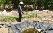Jesús Rodríguez muestra un agujero artesanal donde almacenan la poca agua de lluvia que cae debido a la sequía en El Jícaro (Guatemala).