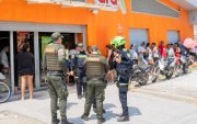 Integrantes de la Policía de Colombia custodian un negocio tras la violencia desatada por las paramilitares ACSN en Santa Marta (Colombia).