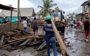 Un miembro de la Marina de México transporta una viga de madera durante la emergencia causada por el huracán Polo en Playa Azul, México, el 24 de septiembre de 2026.
