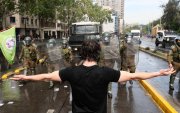 Carabineros de Chile y un manifestante se enfrentan durante la movilización nacional convocada por la Confederación de Estudiantes de Chile.