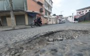 Los baches y el desgaste del asfalto obligan a los conductores a reducir la velocidad y cambiar de trayectoria para continuar por las calles del sector.