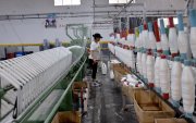 Una persona realiza su trabajo en una industria de textil, en Quito.