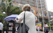 Una adulta mayor camina al pie del edificio del Instituto Ecuatoriano de Seguridad Social.