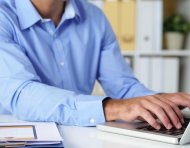 Cropped image of businessman working on laptop