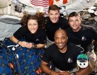 Tripulación de la misión Artemis II posa en microgravedad dentro de la cápsula Orion durante su viaje alrededor de la Luna.