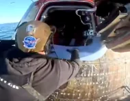 Personal de recuperación abre la escotilla de la cápsula Integrity tras el amerizaje de la misión Artemis II.