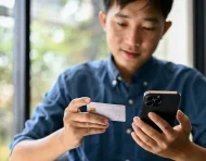 Uso de tarjeta y celular en una transacción digital, reflejo de operaciones que pueden generar errores de transferencia.