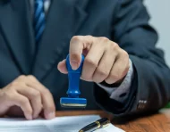 Referencial.Un funcionario estampa la autorización en un documento, requisito indispensable para la salida de menores en Ecuador.