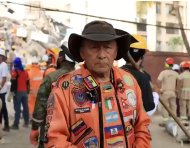 Un rescatista de Topos Azteca explica las posiciones de seguridad durante un terremoto, mientras equipos trabajan entre los escombros.