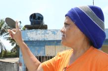 Janeth Maenza muestra su tanque de agua derretido por el calor. Su casa está a seis metros del incendio.