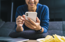 Una persona al manipular un teléfono celular. Referencial.