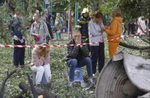 La gente local reacciona cerca del lugar de un ataque aéreo contra un edificio residencial de nueve pisos en Kiev, Ucrania.