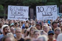 Manifestantes sostuvieron carteles en los que se leen “6 niños muertos y contando” (i) y “10.796 mentiras y contando” (d) durante una manifestación en los exteriores de la Casa Blanca. La protesta del pasado viernes exigió el cierre de los centros de dete