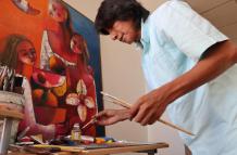 El pintor ecuatoriano Olmedo Quimbita hace una demostración de pintura durante una entrevista.
