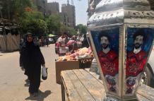 Una mujer observa un farol de colores, típico del mes sagrado de Ramadán, en el barrio islámico de El Cairo, que este año son diferentes ya que lucen el rostro del futbolista egipcio Mohamed Salah, que alumbra las calles y hogares del país. 