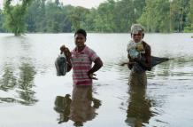 Personas caminan en el área sumergida por la inundación en Kurigram, Bangladesh 
