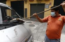 Un ciudadano de Guayaquil retira las cenizas del volcán en un barrio de Guayaquil.