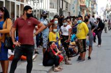 Grupos de personas con tapabocas hacen fila para comprar en un mercado, el 11 de marzo de 2021, en La Habana (Cuba).