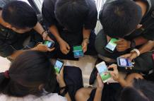 Estudiantes tailandeses juegan al videojuego ""Pokemon Go"" desde su teléfono móvil en un centro comercial en Bangkok, Tailandia.