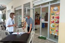 Visita. Funcionaria municipal habla con el administrador de un local.