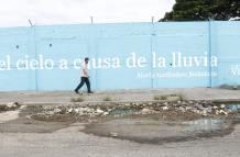 Un aspecto del suburbio muestra el costoso proyecto Letras Vivas junto a un bache.
