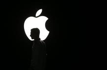 La silueta de un hombre se ve frente al logo de Apple, en una fotografía de archivo.