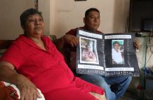 Reclamo. Roberto Farías muestra, junto a su tía, un cartel con la foto de su madre saparecida desde la pandemia.