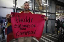 Un aficionado sostiene un cartel de apoyo al exfutbolista colombiano Freddy Rincón, quien sufrió un grave accidente de tráfico en la madrugada de este lunes, hoy, a las afueras de la clínica Imbanaco donde se encuentra hospitalizado, en Cali (Colombia).