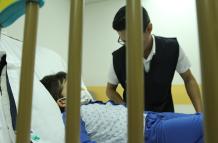 Atención. Un niño se recupera de un tratamiento hospitalario, mientras recibe la visita de un conocido.
