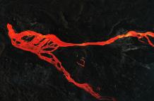 Imagen de archivo tomada con un dron de una colada de magma que discurre hacia el mar rodeada de roca volcánica por la erupción del volcán Cumbre Vieja.