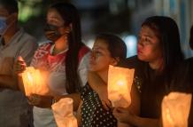 Familiares de los reclusos asesinados en la mayor masacre carcelaria de Ecuador sostienen velas hoy, en una misa y vigilia en Guayaquil (Ecuador).