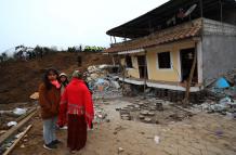 Pobladores observan los daños causados por un deslizamiento de tierra hoy, en Alausí.