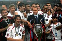 Silvio Berlusconi, presidente del AC Milán, sostiene junto a sus jugadores el trofeo de campeones