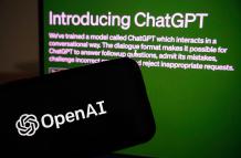 Vista del logo de la empresa OpenAI junto a un monitor en el que se ve el ingreso a ChatGPT, en una fotografía de archivo.