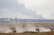 Soldados israelíes en vehículos militares recorren un área a lo largo de la frontera con Gaza, en el sur de Israel, este lunes.