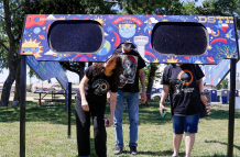 Una familia mira a través de un par de gafas gigantes especiales para el eclipse solar en el Veterans Memorial Park en Dripping Springs, Texas