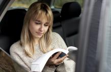 beautiful-blonde-woman-reading-car